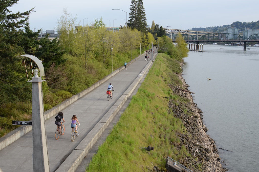Portland bicyclists riding next to river on paved trail